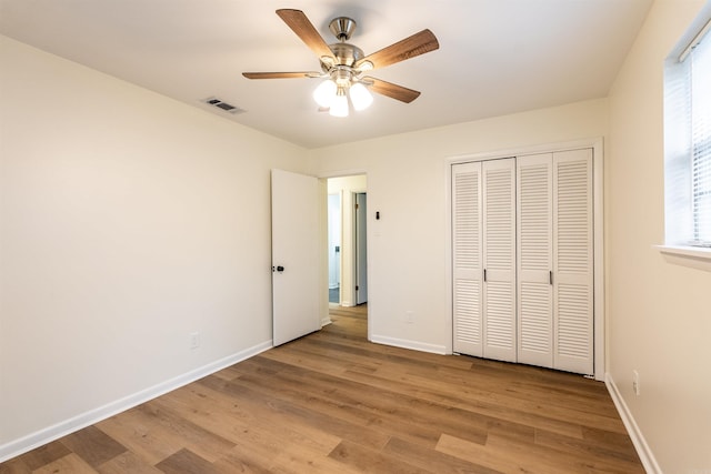 unfurnished bedroom featuring multiple windows, ceiling fan, a closet, and light hardwood / wood-style floors