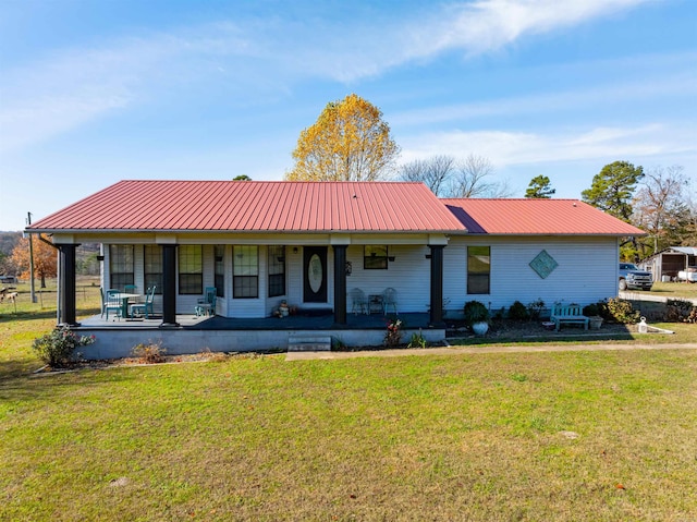 ranch-style home featuring covered porch and a front yard