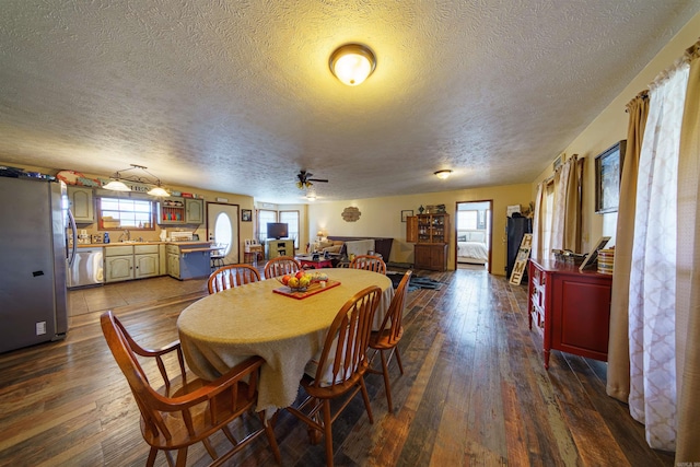 dining space with dark hardwood / wood-style flooring, ceiling fan, plenty of natural light, and a textured ceiling