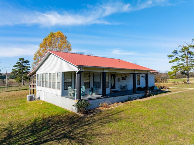 ranch-style house with a sunroom, central AC unit, covered porch, and a front yard