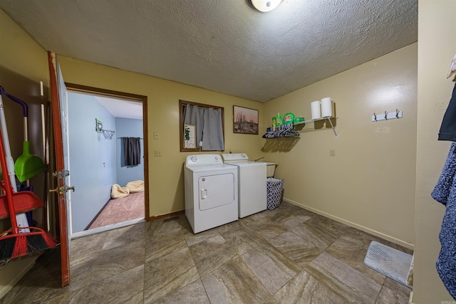 clothes washing area featuring washing machine and dryer and a textured ceiling