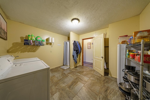 laundry area featuring a textured ceiling and washing machine and clothes dryer