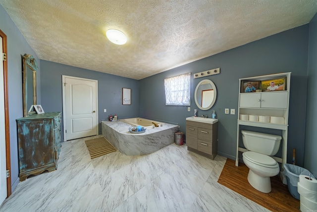 bathroom with a tub, vanity, a textured ceiling, and toilet