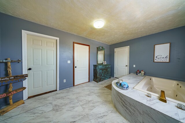 bathroom featuring a textured ceiling and tiled bath