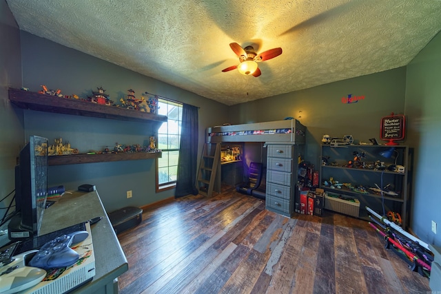 bedroom with a textured ceiling, dark hardwood / wood-style floors, and ceiling fan