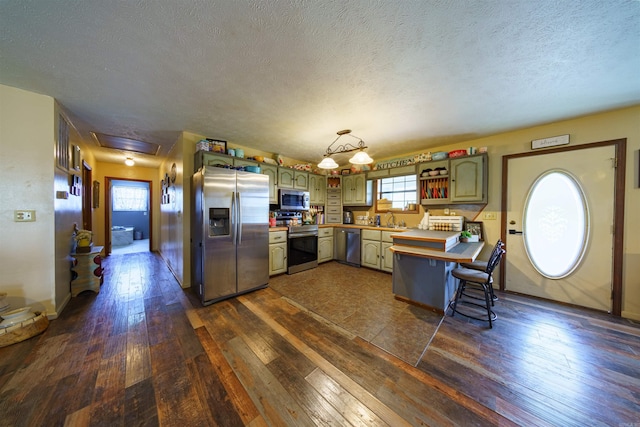 kitchen featuring sink, dark hardwood / wood-style flooring, a textured ceiling, and appliances with stainless steel finishes