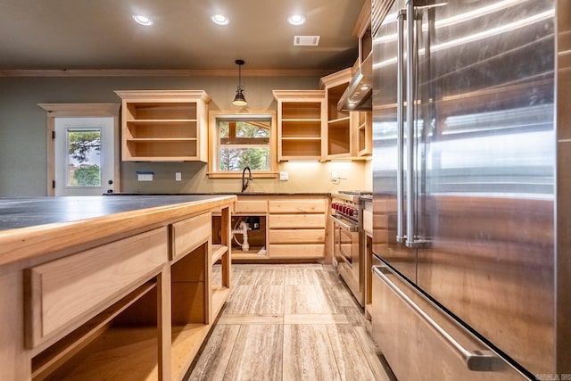 kitchen featuring high end appliances, sink, decorative light fixtures, light brown cabinetry, and ornamental molding