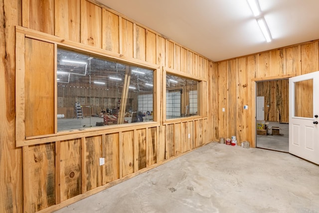 empty room with wooden walls and concrete floors