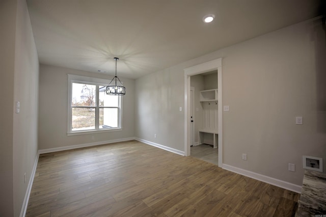 unfurnished dining area with light wood-type flooring and a notable chandelier