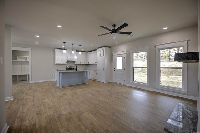 unfurnished living room with light wood-type flooring and ceiling fan