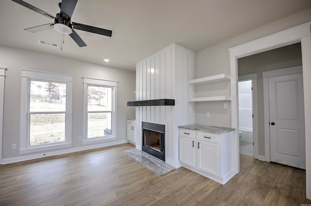 unfurnished living room with ceiling fan and light hardwood / wood-style floors