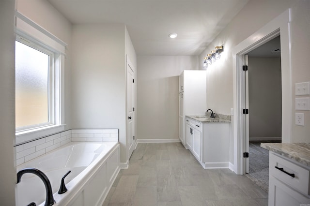 bathroom with vanity and a bath