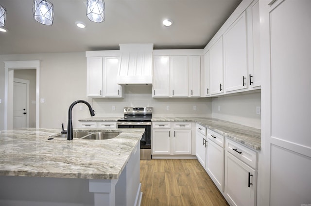 kitchen featuring light stone countertops, light wood-type flooring, sink, white cabinets, and stainless steel electric range