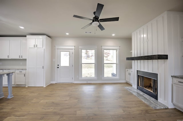 unfurnished living room featuring ceiling fan and light hardwood / wood-style flooring