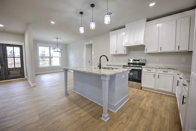 kitchen with white cabinetry, a center island with sink, hanging light fixtures, and stainless steel electric range