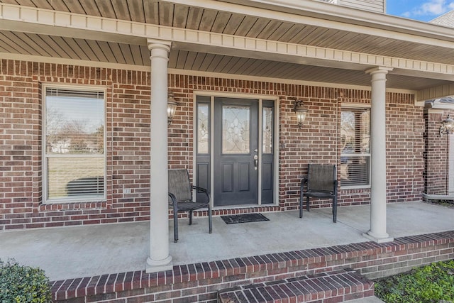 view of exterior entry featuring covered porch