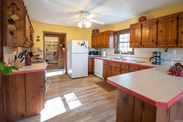 kitchen featuring kitchen peninsula, white appliances, ceiling fan, sink, and light hardwood / wood-style floors