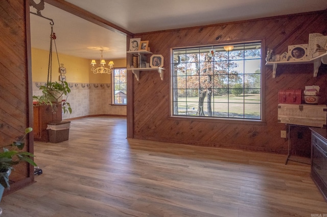 dining room featuring a chandelier, hardwood / wood-style floors, and wooden walls