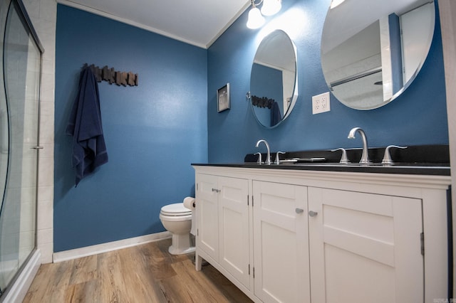 bathroom featuring hardwood / wood-style floors, vanity, crown molding, toilet, and an enclosed shower