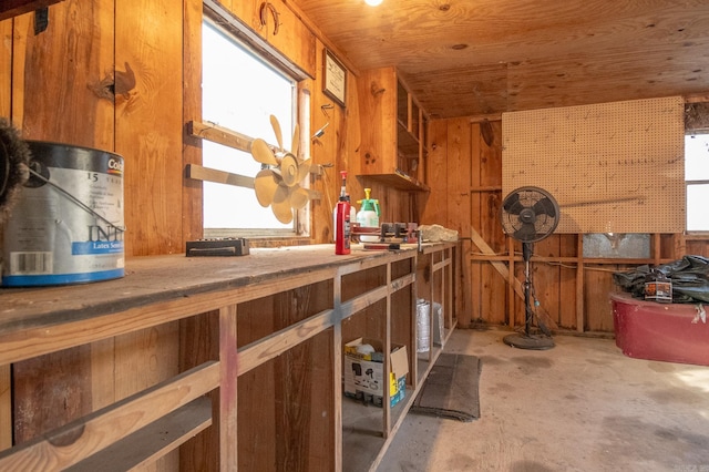 kitchen featuring wooden walls, concrete floors, and wooden ceiling