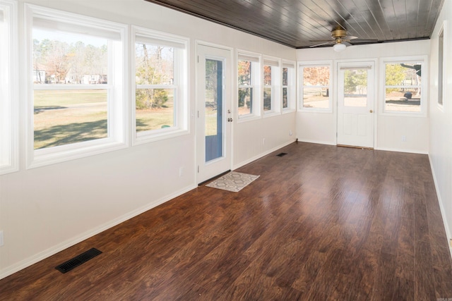 unfurnished sunroom featuring ceiling fan, a healthy amount of sunlight, and wood ceiling