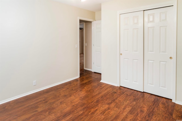 unfurnished bedroom with dark hardwood / wood-style floors and a closet