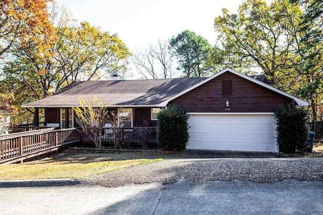 single story home featuring a porch and a garage