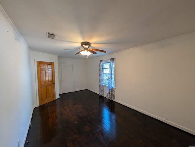 empty room featuring ceiling fan, dark hardwood / wood-style floors, and ornamental molding