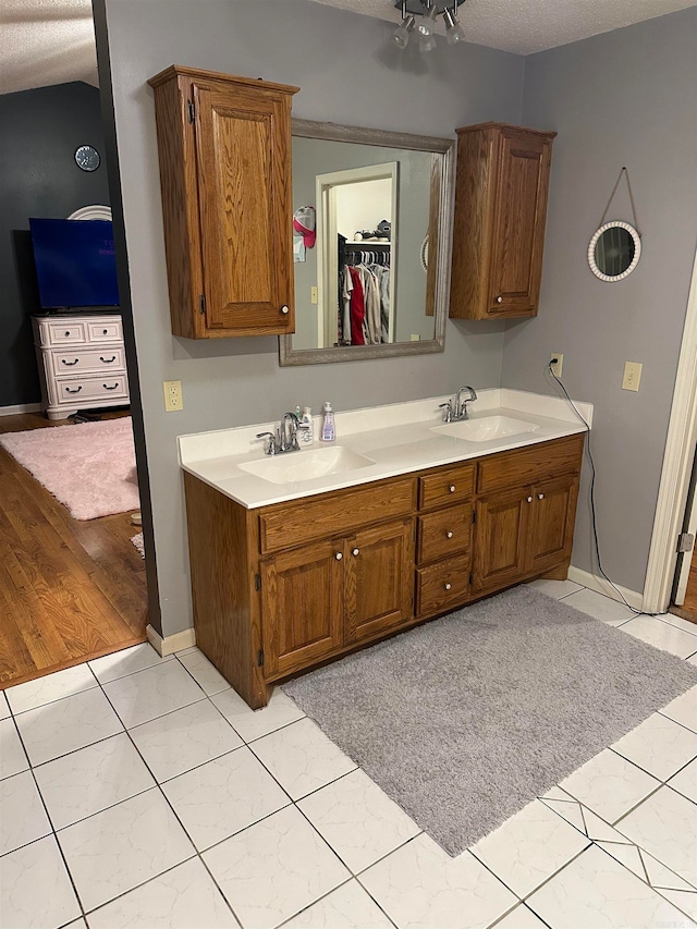 bathroom featuring vanity, a textured ceiling, and tile patterned flooring