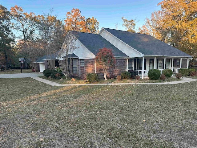 view of front of home with covered porch, a front yard, and a garage