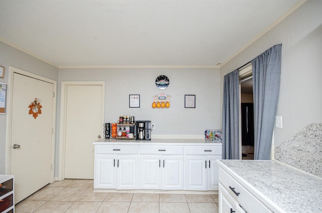 kitchen featuring crown molding, white cabinets, and light tile patterned floors