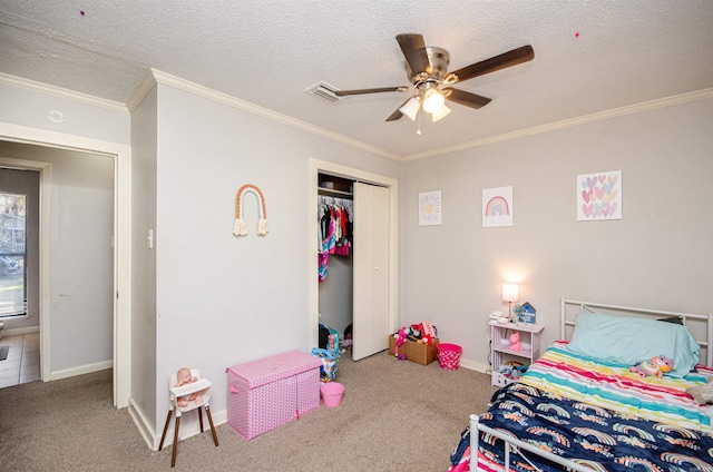 carpeted bedroom with ceiling fan, a closet, a textured ceiling, and ornamental molding