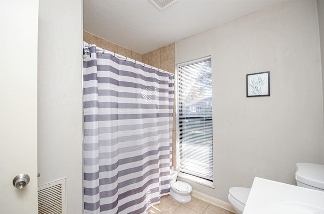 bathroom featuring tile patterned floors, walk in shower, a textured ceiling, and toilet