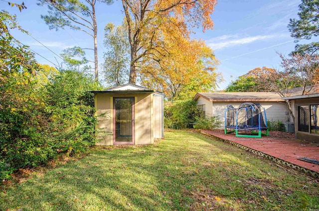 view of yard featuring a storage shed, a trampoline, and central air condition unit