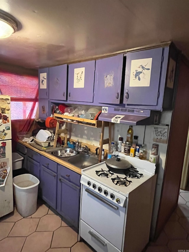 kitchen featuring blue cabinetry, sink, range hood, white appliances, and light tile patterned floors