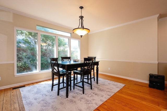 dining room with light hardwood / wood-style floors and ornamental molding