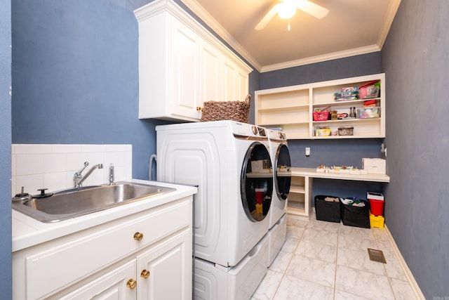 laundry room with washing machine and clothes dryer, ceiling fan, sink, cabinets, and crown molding