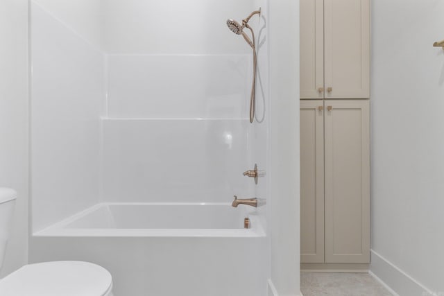 bathroom with tile patterned flooring, tub / shower combination, and toilet