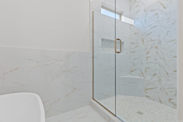 bathroom featuring separate shower and tub and tile walls