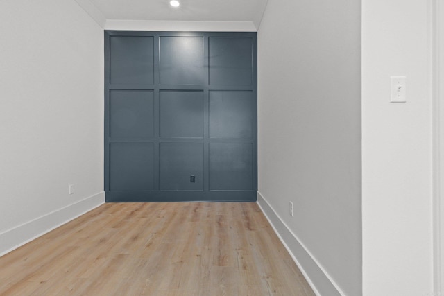 spare room with ornamental molding and light wood-type flooring