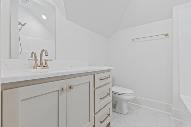 bathroom featuring toilet, vanity, and vaulted ceiling