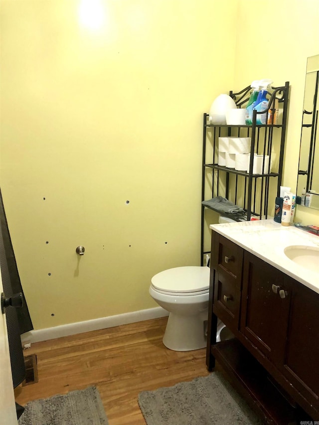 bathroom with vanity, toilet, and wood-type flooring