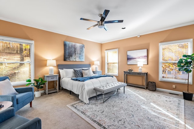 carpeted bedroom with ceiling fan and ornamental molding