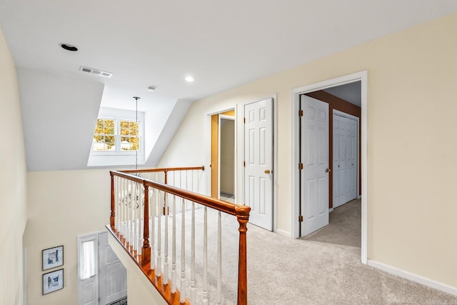 hall with light colored carpet and lofted ceiling