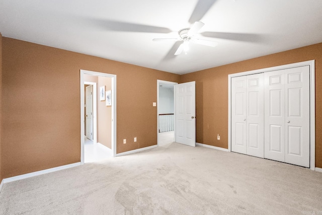 unfurnished bedroom featuring ceiling fan, light carpet, and a closet