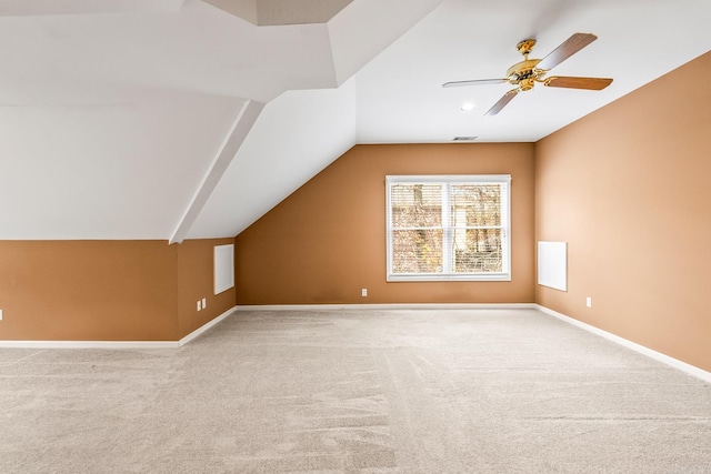 additional living space featuring light carpet, ceiling fan, and vaulted ceiling