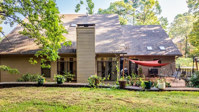 rear view of property featuring a yard and a deck