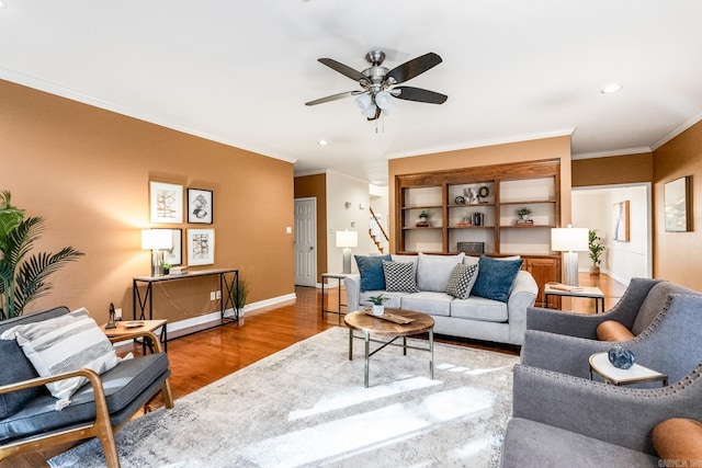 living room with crown molding, ceiling fan, and light wood-type flooring