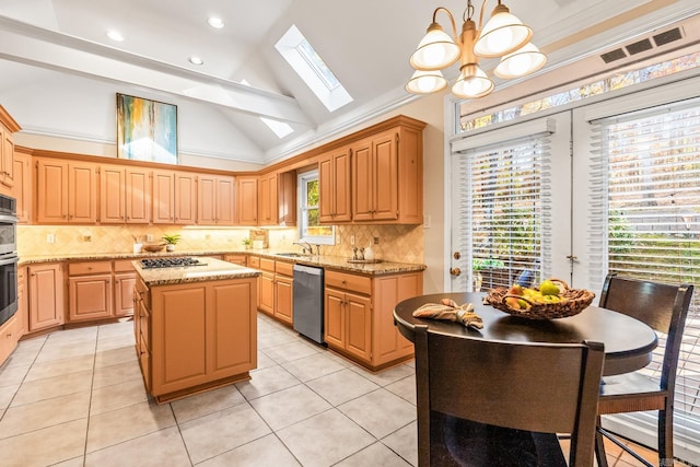 kitchen featuring a center island, lofted ceiling with skylight, a chandelier, decorative light fixtures, and appliances with stainless steel finishes