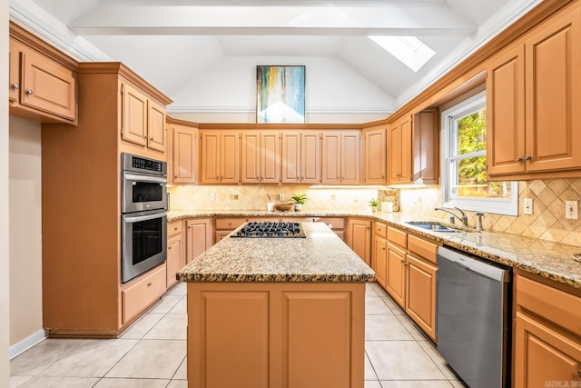 kitchen with lofted ceiling with skylight, sink, a kitchen island, and appliances with stainless steel finishes